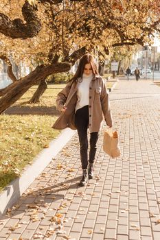 A stylish brunette woman walks around the autumn city. The season is autumn.