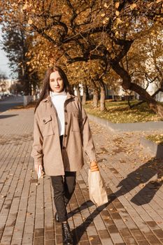 A stylish brunette woman walks around the autumn city. The season is autumn.