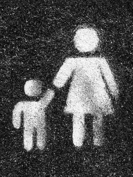 Family symbol. Mother and son are kept each other's hands. Love. Graffiti on asphalt as background.