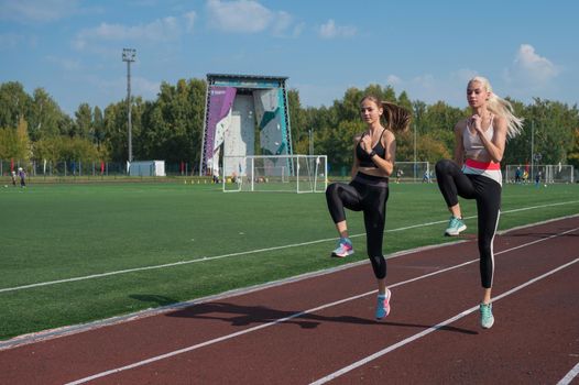 Two athlete young woman runnner are training at the stadium outdoors