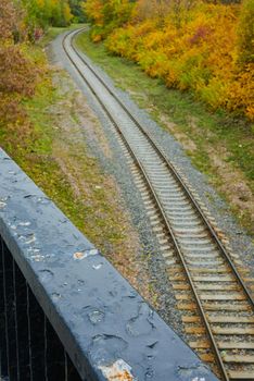 Railroad surrounded by autumn nature. Railing of the old bridge on the background of the railway. High quality photo