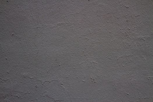 Old peeling paint on the wall. Dark gray abstract background.Background from gray stucco.