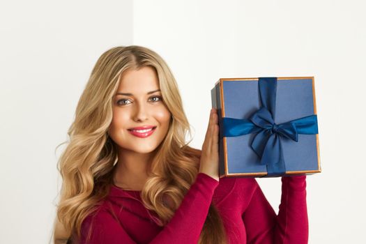 Happy woman holding a gift for birthday, anniversary, wedding, Valentines day or Christmas, luxury holiday present or beauty box subscription delivery concept