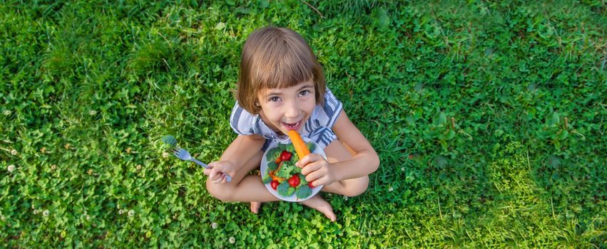 child eats vegetables broccoli and carrots. Selective focus.