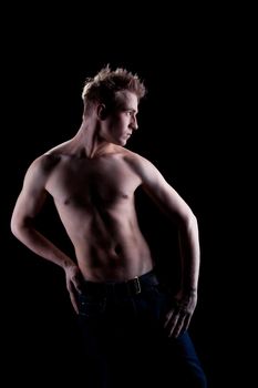 Studio portrait of young man with naked torso in jeans