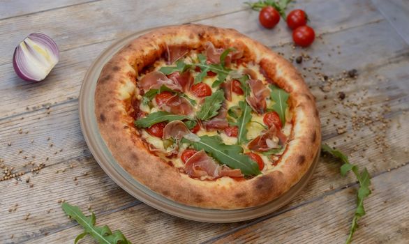 Pizza with cheese and tomato on wooden background with onion. High quality photo