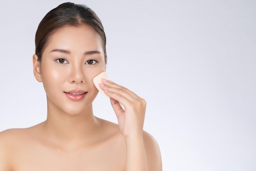 Gorgeous woman applying her cheek with dry powder. Portrait of younger with perfect makeup and healthy skin concept.