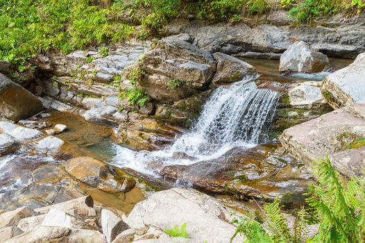 waterfall in the mountains of the mountain river. sochi rosa khutor mendelikha waterfalls park. photo