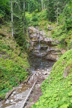 waterfall in the mountains of the mountain river. sochi rosa khutor mendelikha waterfalls park. photo