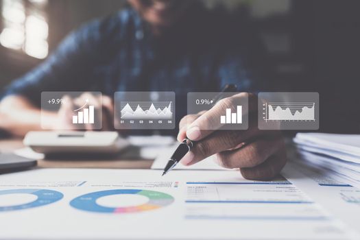 Businessman hand holding pen and pointing at financial paperwork with social network diagram.