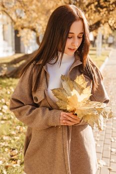 A stylish brunette woman walks around the autumn city. The season is autumn.