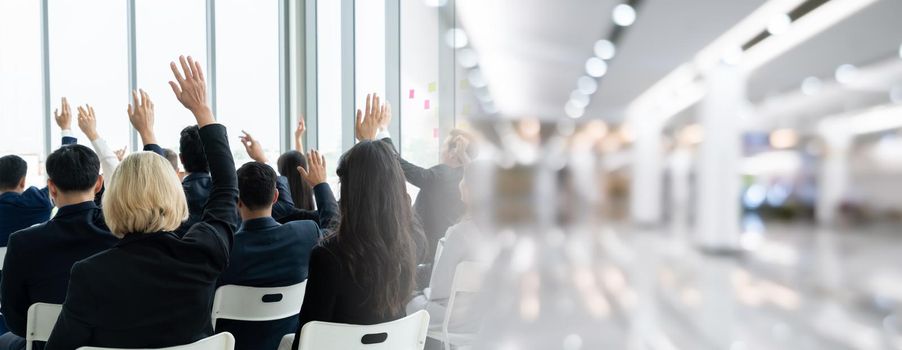 Group of business people meeting in a seminar conference widen view . Audience listening to instructor in employee education training session . Office worker community summit forum with speaker .