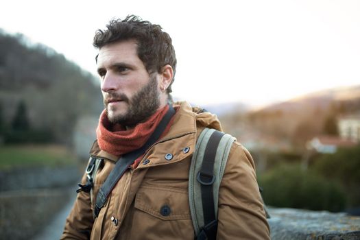 Portrait of caucasian man outdoors in nature during fall season. Adult male hiker going on excursion.