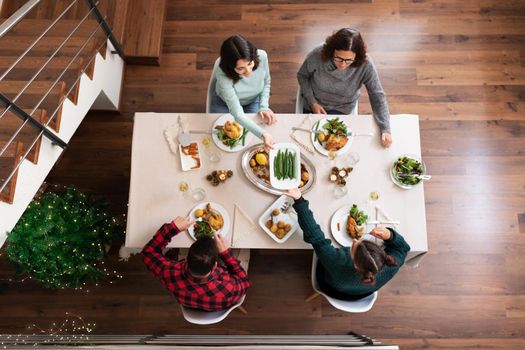 Top view of caucasian family having Christmas dinner together at home. Festive celebration. Holiday concept.