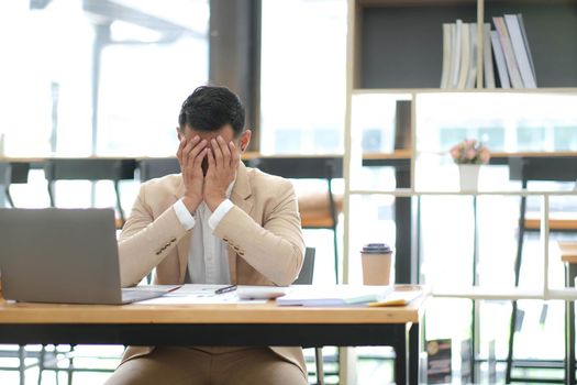 Businessmen feel stressed and tired sitting at his office with a laptop,mobbing concept.