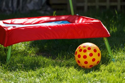 Child's trampoline and ball in a home garden setting