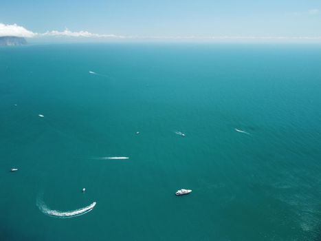 Aerial boat race. Luxury cruise trip. View from above of white boat on deep blue water. Aerial view of rich yacht sailing sea. Motor boat racing wave. Summer journey on luxury ship