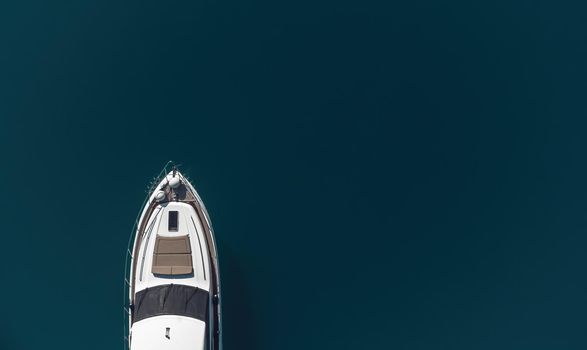 Aerial boat race. Luxury cruise trip. View from above of white boat on deep blue water. Aerial view of rich yacht sailing sea. Motor boat racing wave. Summer journey on luxury ship