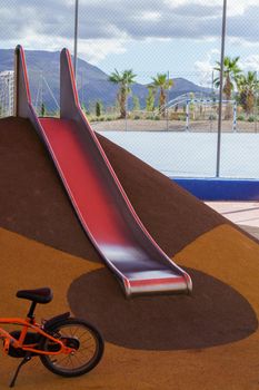 slide and bicycle in a playground, playground equipment for children