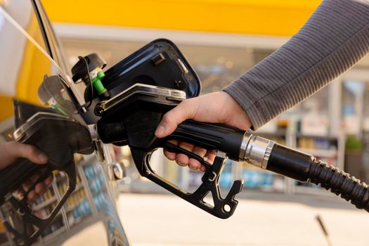 Car refuelling on the petrol station. Man refilling the car with fuel. Close up view. Gasoline, diesel is getting more expensive. Petrol industry and service. Petrol price and oil crisis concept