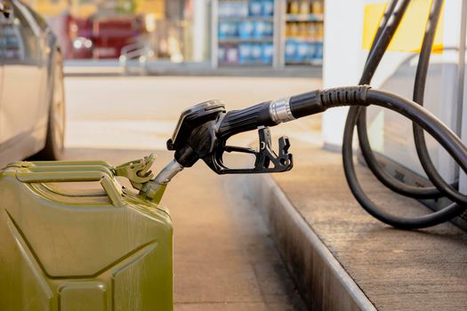 Refilling canister with fuel on the petrol station. Close up view. Fuel, gasoline, diesel is getting more expensive. Petrol industry and service. Petrol price and oil crisis concept