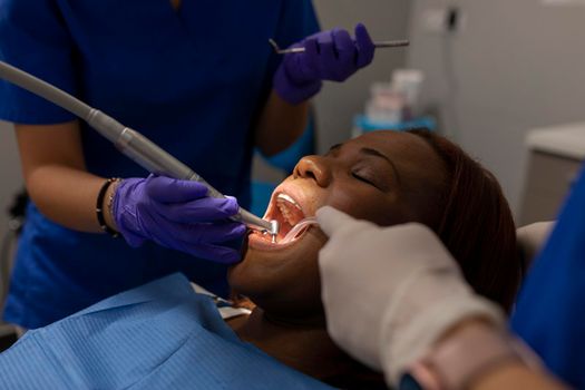 A black woman patient being treated by the dentists at the dental clinic