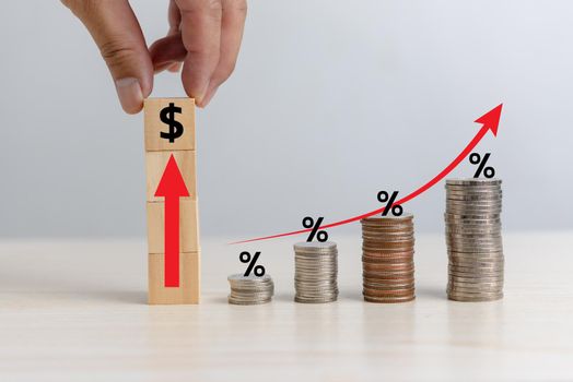 Business finance investments economy stack coin inflation and arrow red with wood cube percentage on desk.