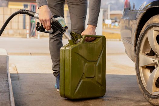 Refilling canister with fuel on the petrol station. Close up view. Fuel, gasoline, diesel is getting more expensive. Petrol industry and service. Petrol price and oil crisis concept