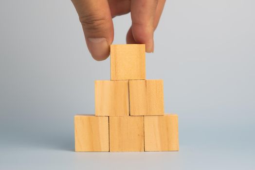 hand holding cube wood block blank on background. copy space