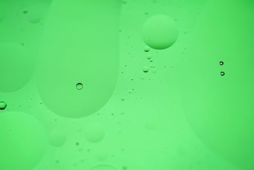 Oil drops in water. Defocused abstract psychedelic pattern image green mint colored. DOF.