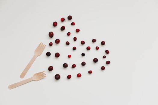 wood fork, bamboo cutlery and berries on white background, zero waste, no plastic, eco-friendly, vegan food concept.