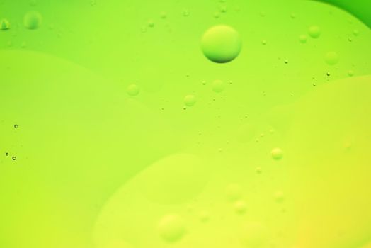 Oil drops in water. Defocused abstract psychedelic pattern image green and yellow gradient colored. DOF.