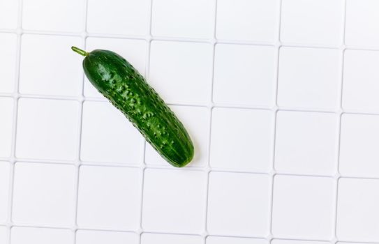 a long, green-skinned fruit with watery flesh, usually eaten raw in salads or pickled. Green fresh cucumber for salad isolated on white