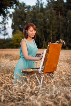 Beautiful female artist working in the field of rye