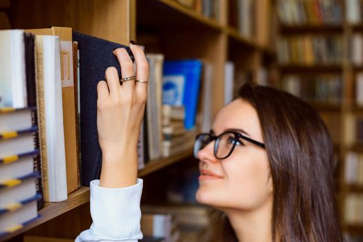 University, library, studying concept; focus on the hand