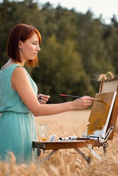 Young girl drawing a beautiful scene of field of wheat