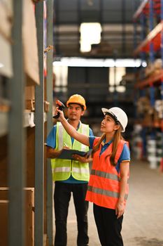 Storehouse employees using barcode scanner to scanning box and checking inventory in retail warehouse.