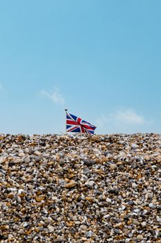 British Union Jack flag flying above a pebble beach