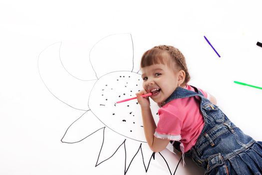 Happy little girl drawing on floor. Isolated on white