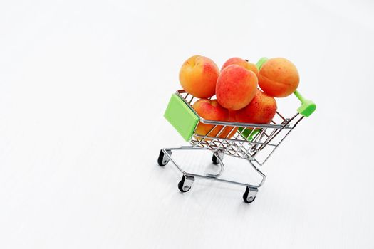 Healthy eating concept. Shopping cart with freshness apricots