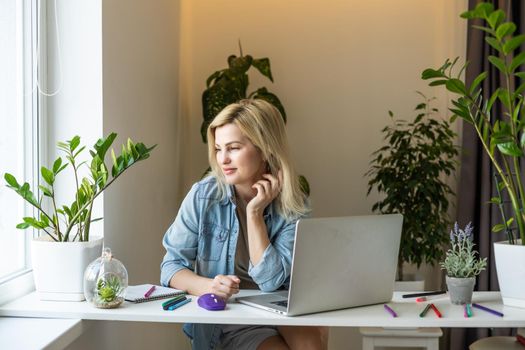 Meeting online. Young woman wearing headphones using laptop watching webinar or doing video chat by webcam. Business conference. E-learning education concept.