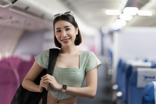 Backpacker asian woman in the airplane while to destination. Travel concept.