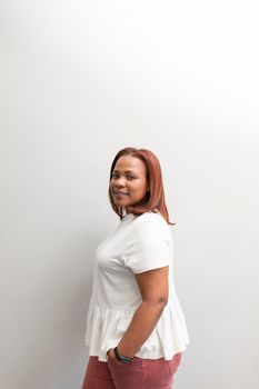 A black woman smiling and posing in the waiting room of the dental clinic where she gets usually treated