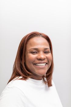 A black woman smiling and posing in the waiting room of the dental clinic where she gets usually treated