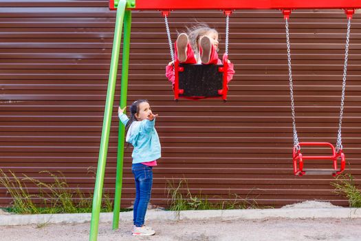 Young child on swing in playground outdoors.
