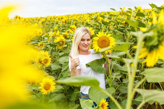 woman with sunflowers enjoying nature and laughing on summer sunflower field