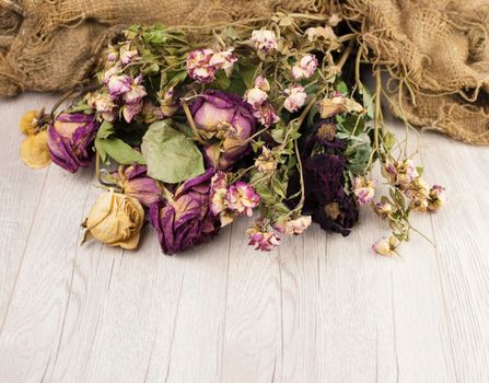 Abstract rose bouquet, Bouquet of dried flowers with old burlap texture on wooden table