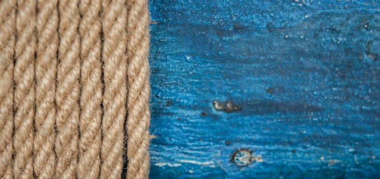 Close-up of a thick hemp rope. Natural rope on an old wooden table. Side view. Soft focus. 