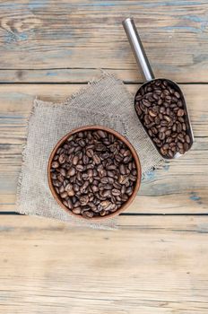 Roasted coffee beans in a wooden bowl. Close up. Copy space. 