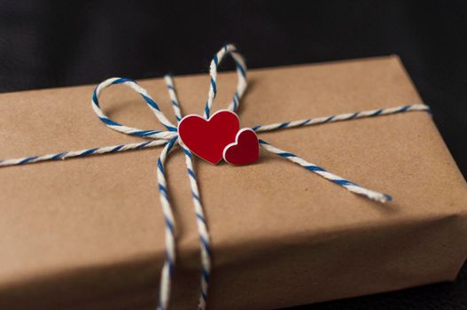 Valentines Day gift box in brown craft paper and red heart.Closeup, copy space